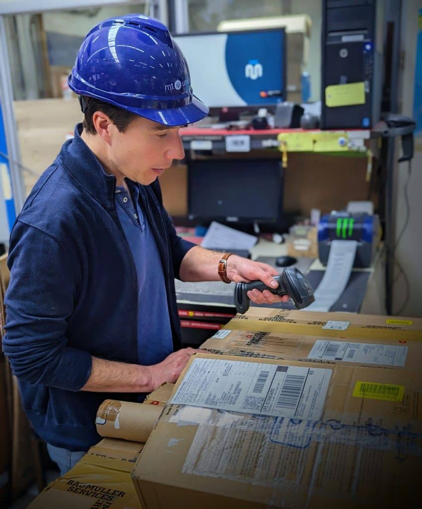 Medewerker van MT Unirepair scant retourpakket in magazijnomgeving