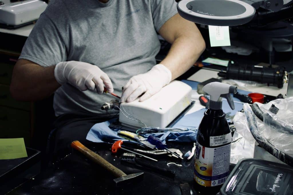 Technicus voert custom repair uit aan elektronisch apparaat op werkbank